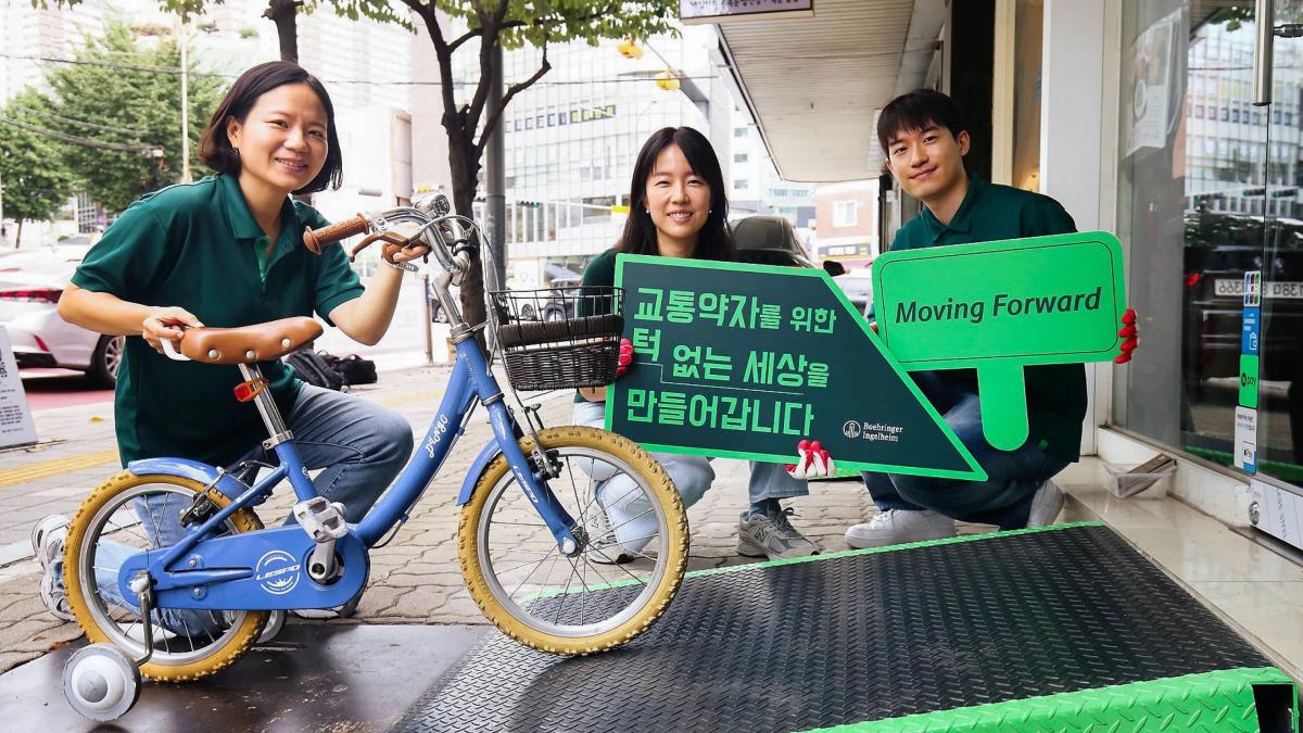people holding up signs and a small bike