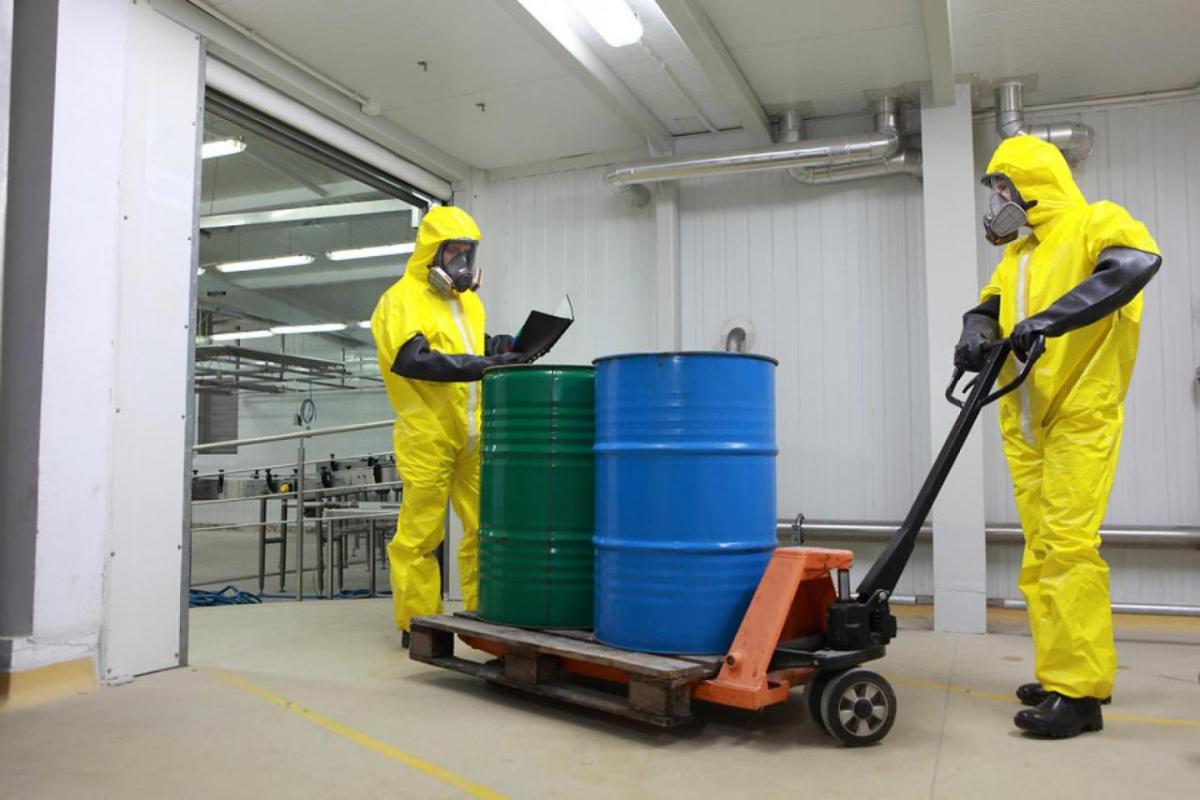 Workers in PPE transport chemicals in a warehouse