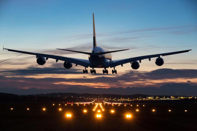 A jet landing on a lighted runway at dusk