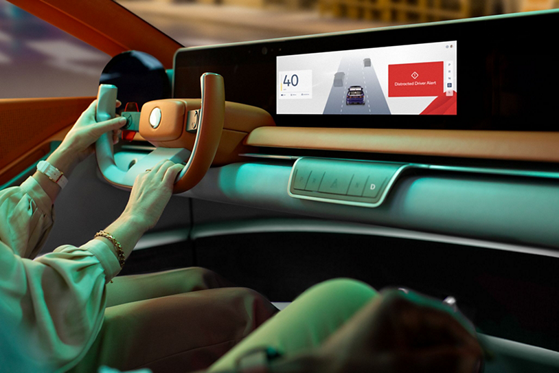 Person driving a car with a screen on the dashboard