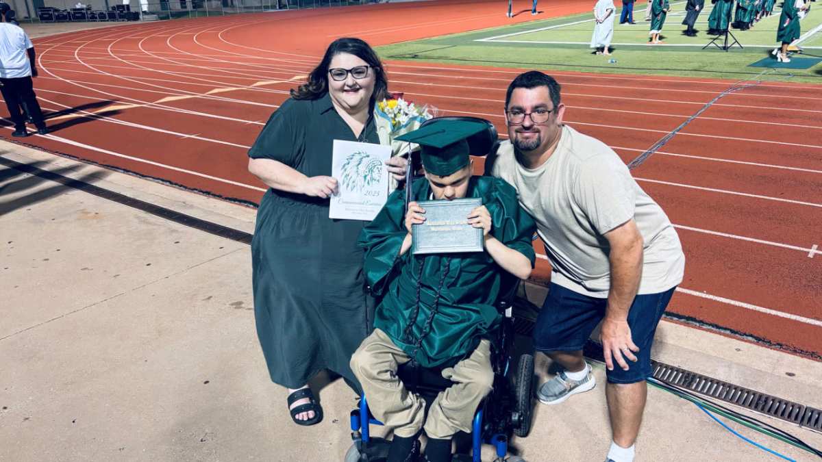 Three people at a graduation ceremony