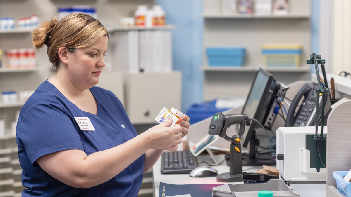 Employee putting a label on a pill bottle