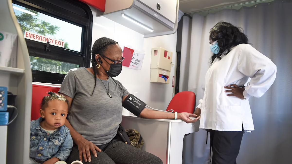 Patient shown with her daughter having her blood pressure checked.