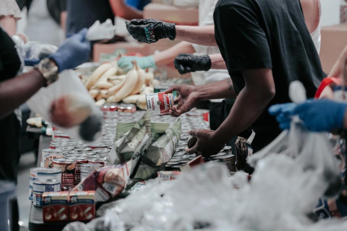 table of food with volunteers hands