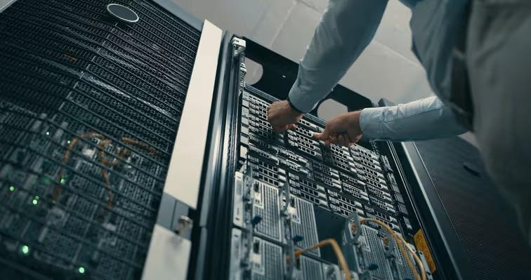 Technician installing server components inside a data center, supporting cloud computing and AI infrastructure.