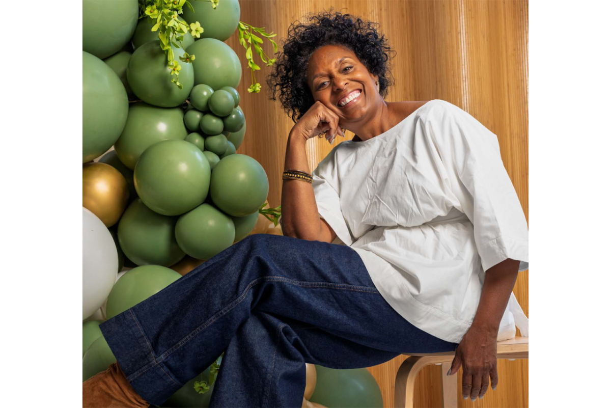 Person sitting on a chair next to green balloons