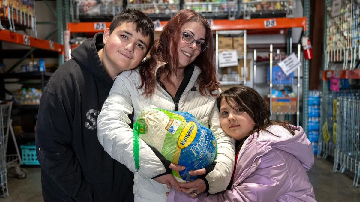 A family shown with a holiday turkey.