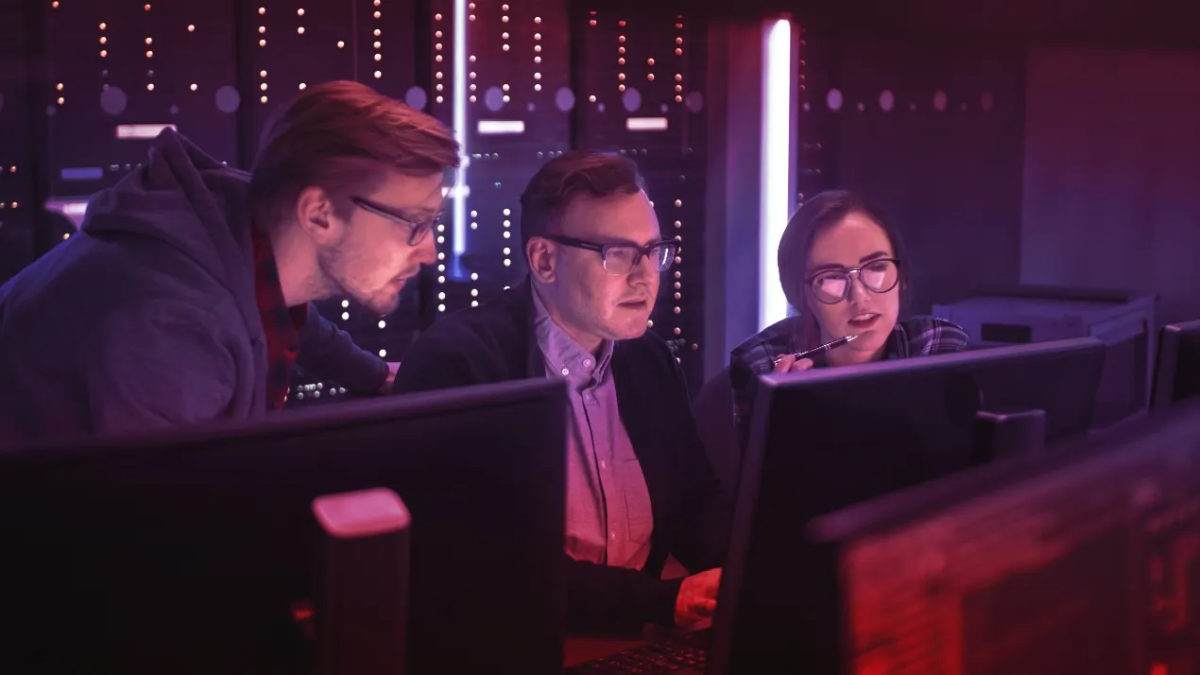 Three people looking at computer monitors