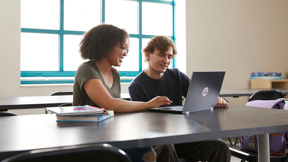 Two people working on laptop together 