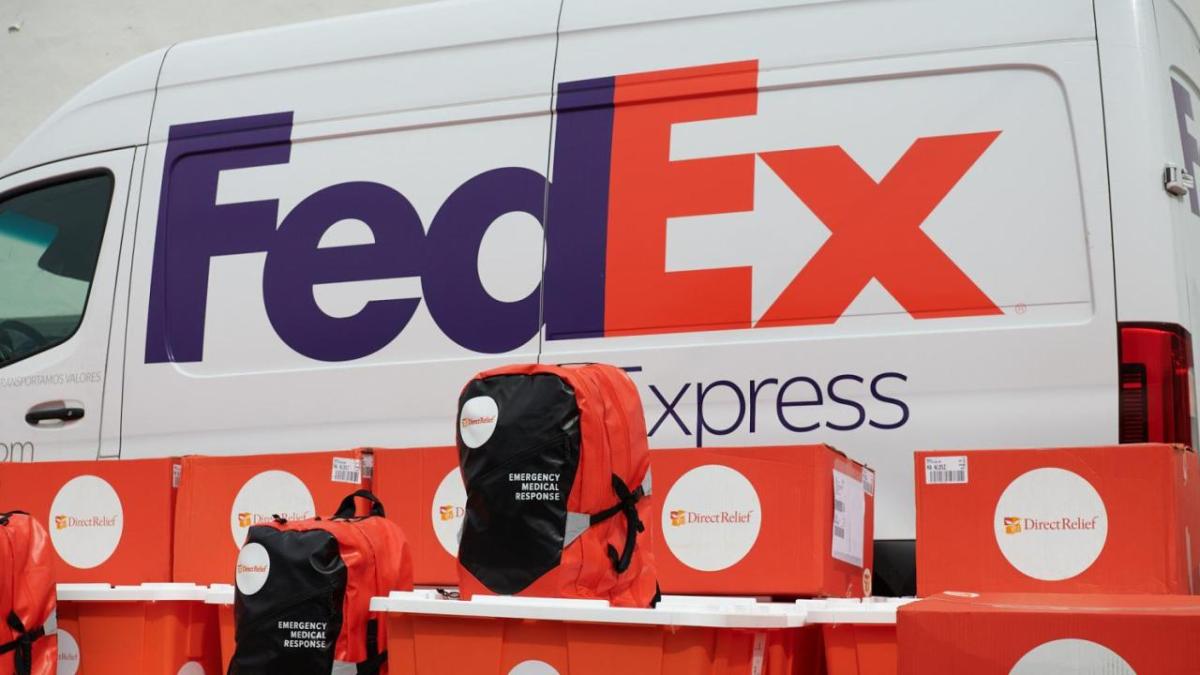 Backpacks and Direct Relief boxes in front of a FedEx Express van