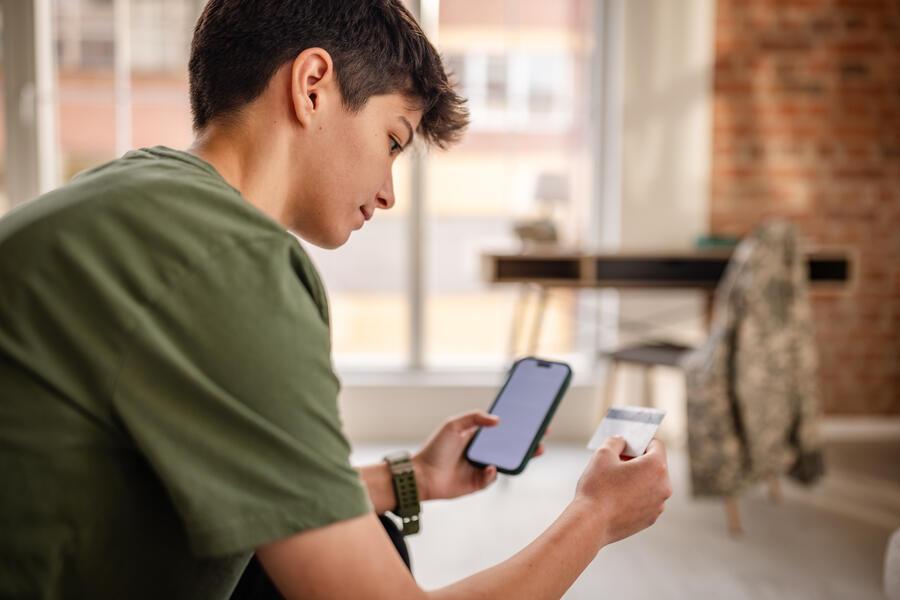 person looking at a card and their phone