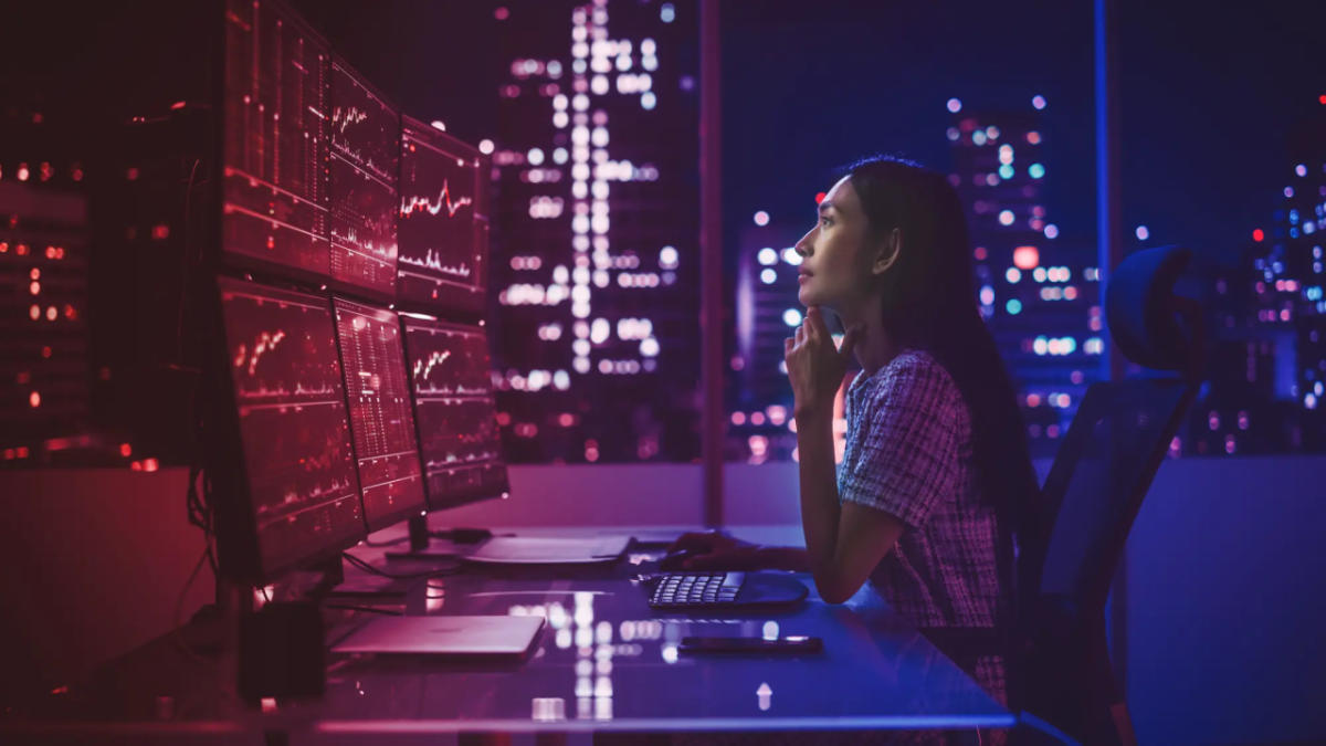 Person looking up at several monitors