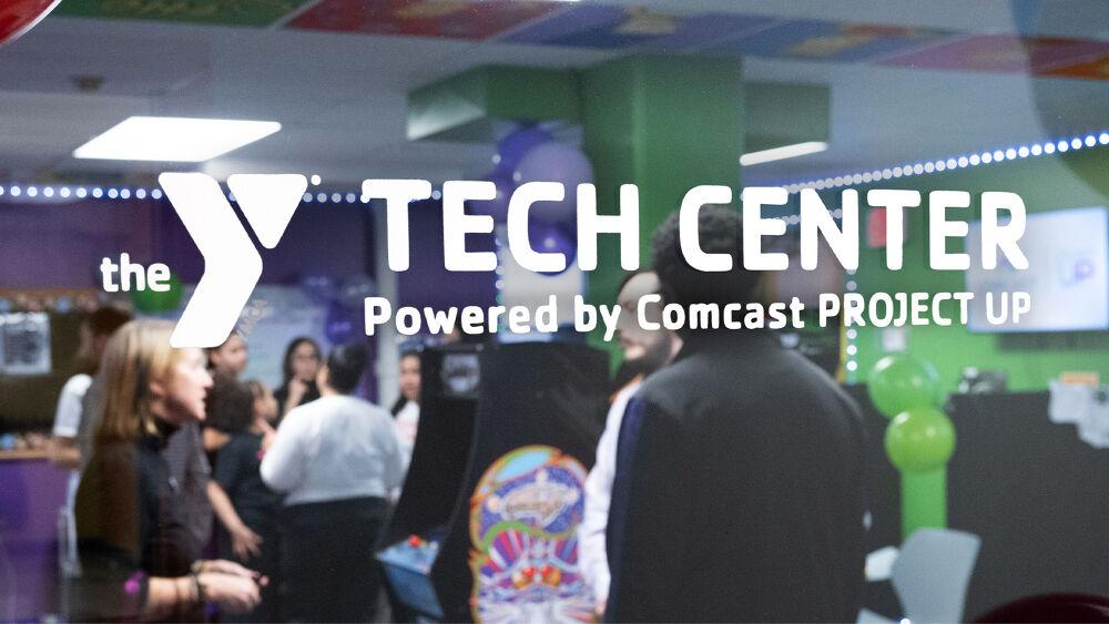 glass door with "the Y Tech Center Powered by Comcast PROJECT UP"