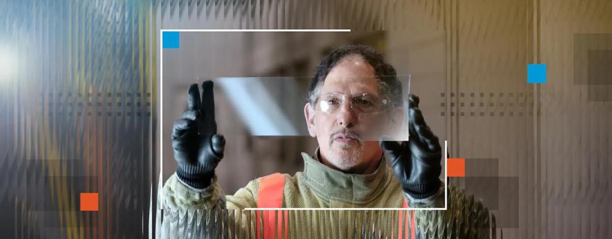 Dean looking through a raised, clear, piece of glass.