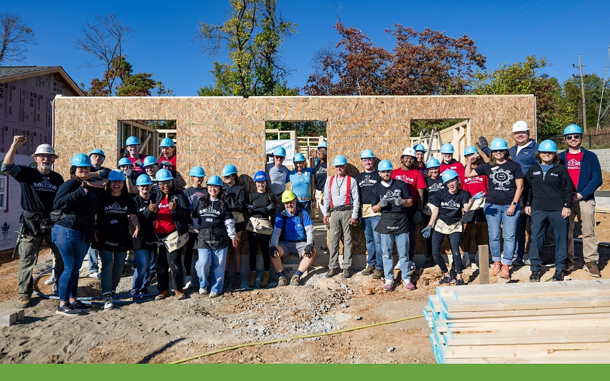 A group of volunteers outside a home being built