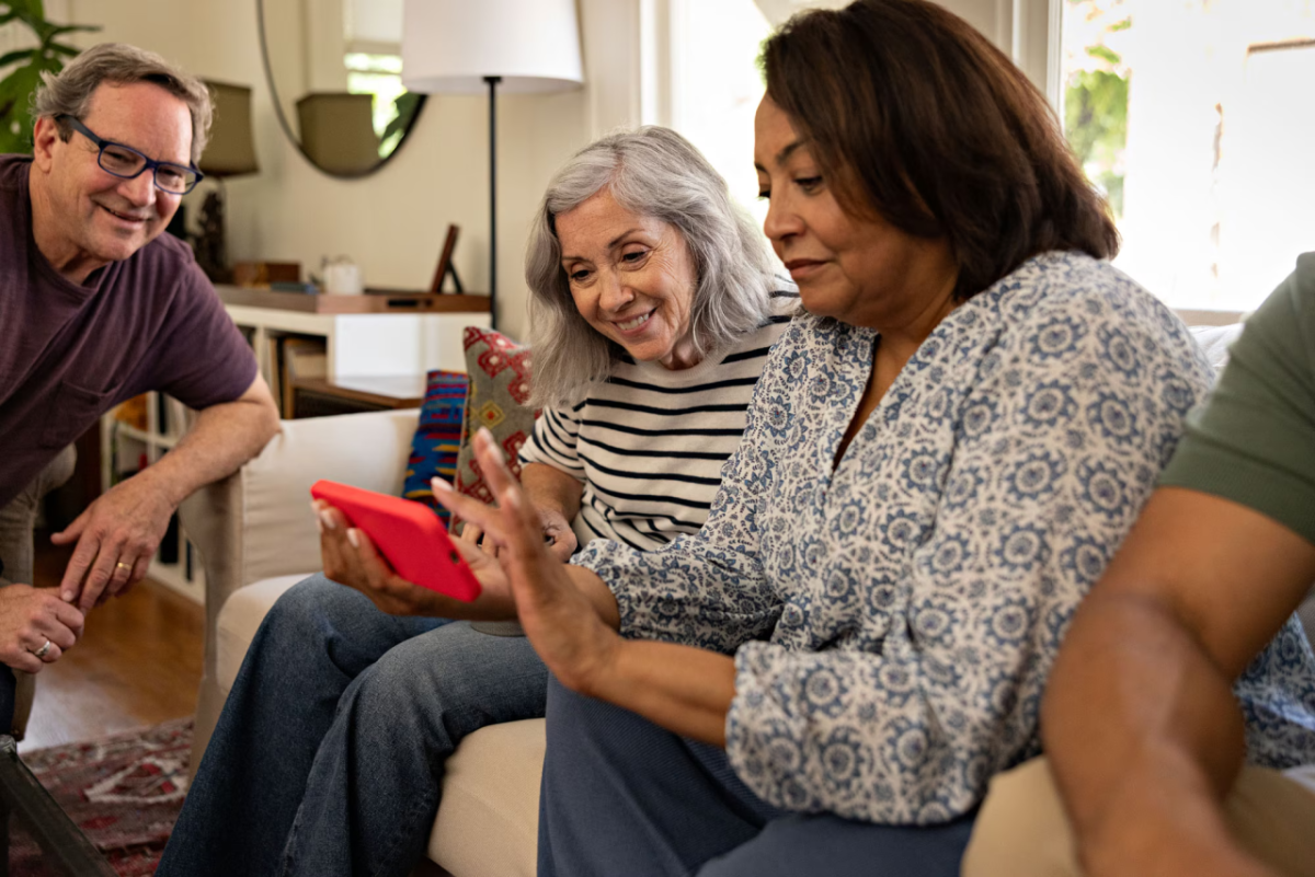 People smiling and using a cell phone