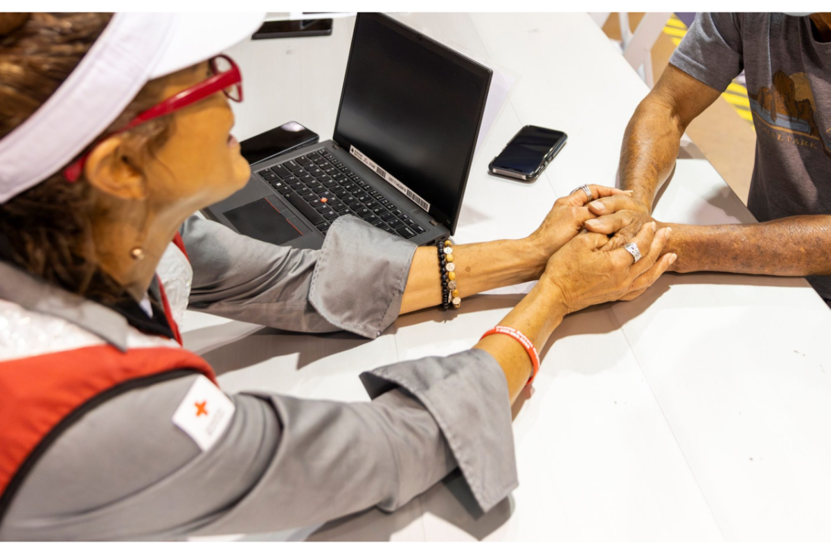 Red Cross volunteer holding someone's hands
