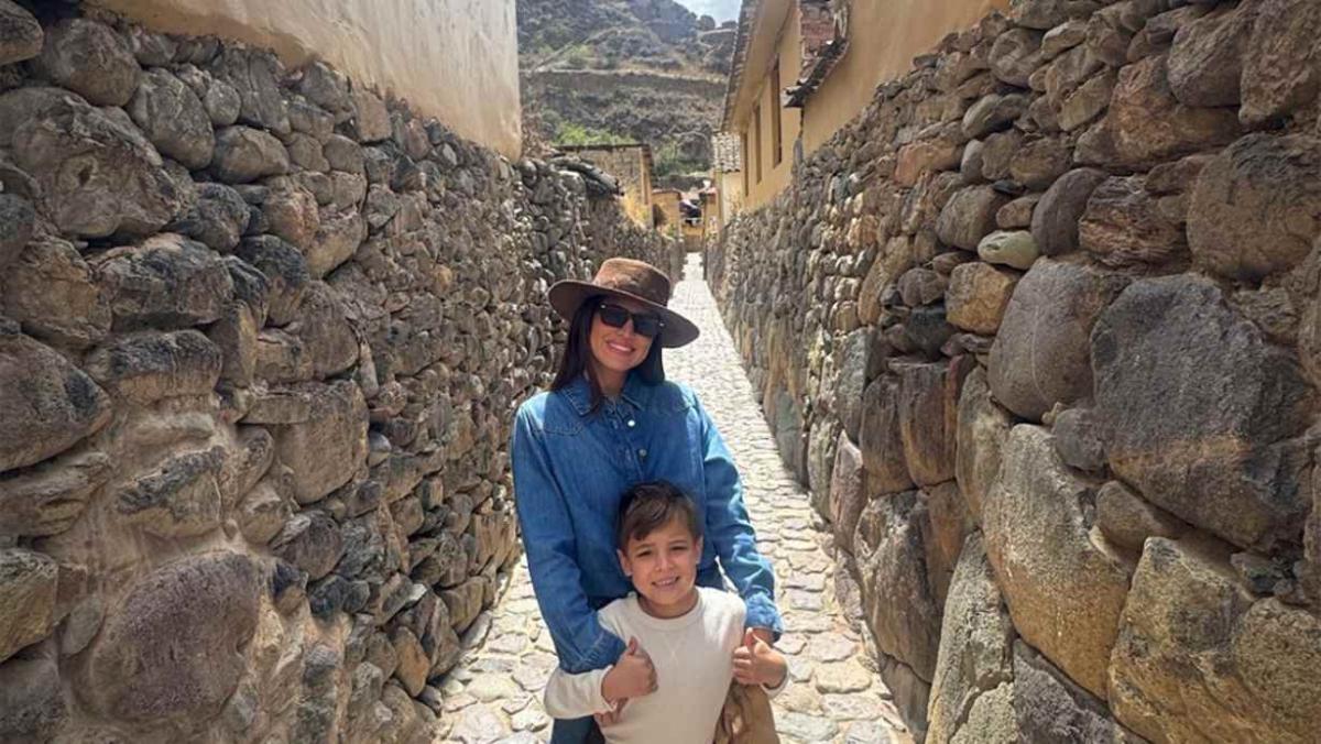 An adult and child standing together on a narrow cobblestone street