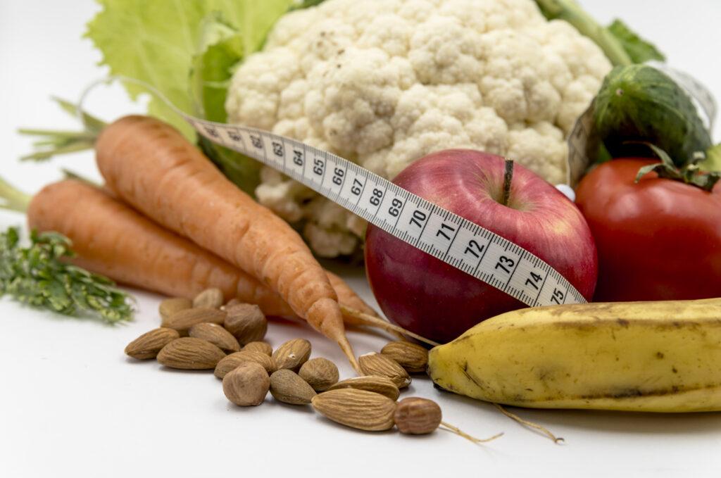fresh vegetables, nuts, and a measuring tape