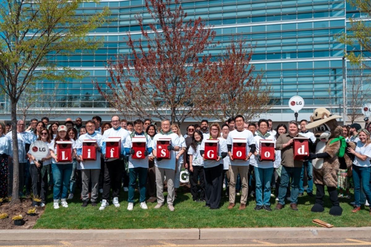 A group of people outside of a building, holding letters that spell "life's good."