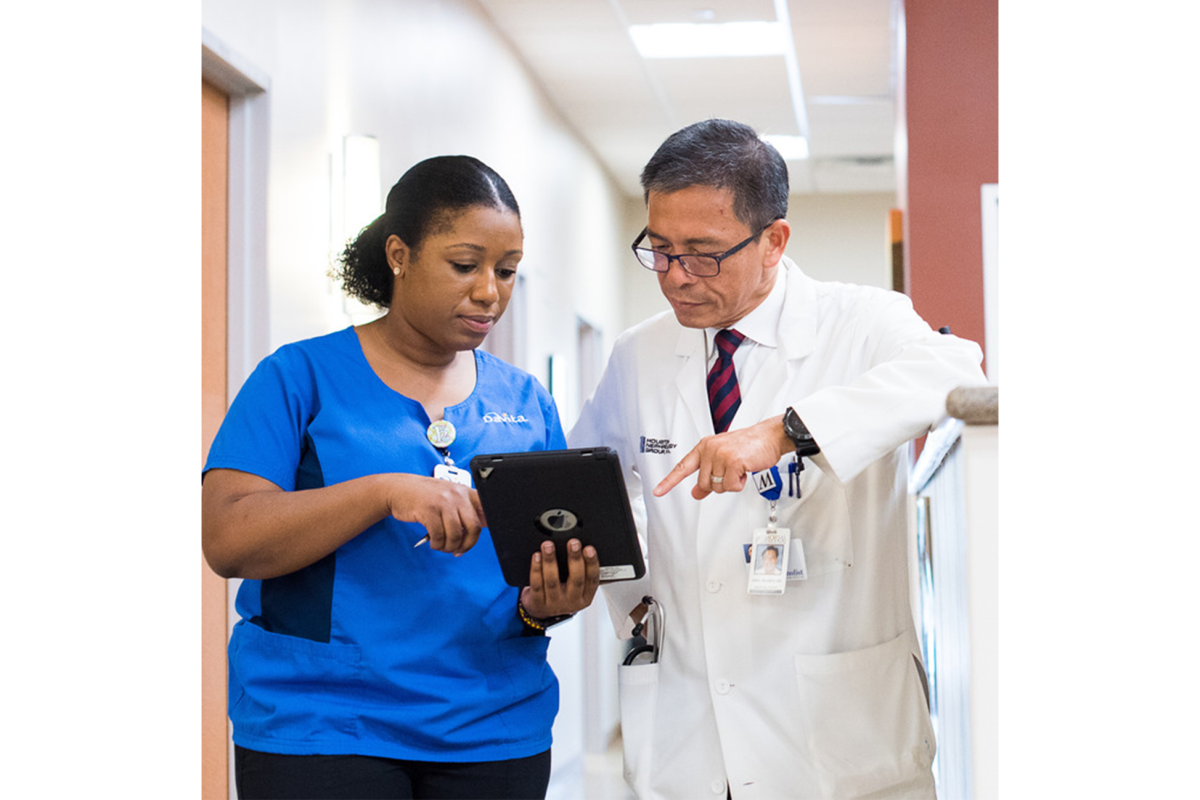 2 healthcare workers looking at a tablet