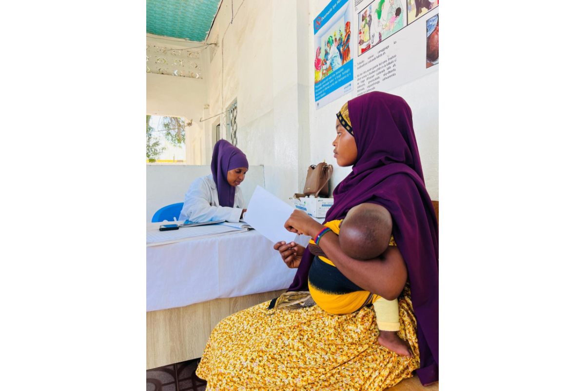 At an Action Against Hunger-supported clinic in Kismayo, a mother is informed about the importance of vaccines for malnutrition prevention. 