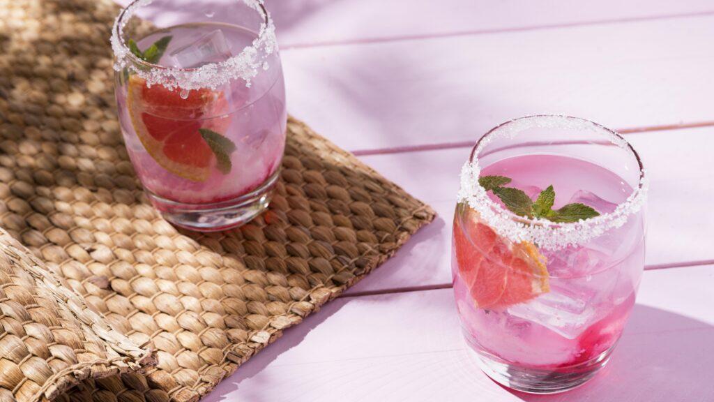 two sugar-rimmed glasses of a pink drink