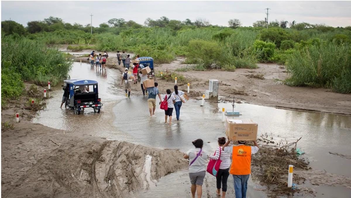 Doctors walk or are transported on a truck after attending to a medical volunteer campaign supported by local health organization Vida Peru, with medical aid from Direct Relief, during flooding from the 2017 El Niño events in the country. (Photo by Enrique Castro-Mendivil for Direct Relief)