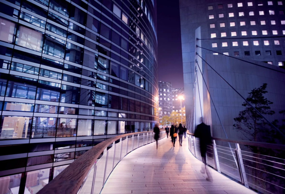 People on a walkway between two tall buildings