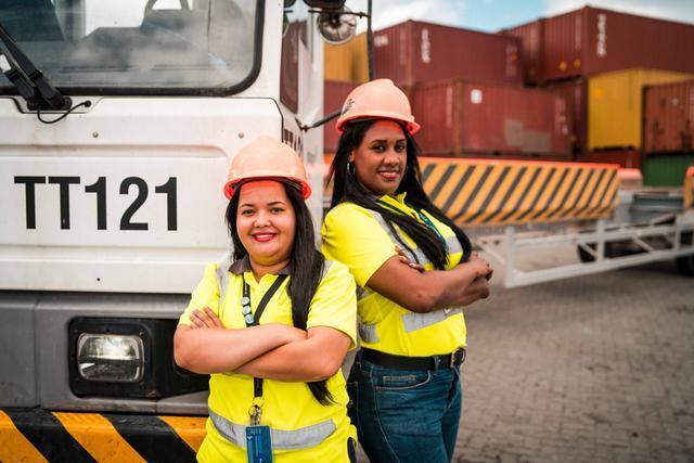 Female employees stand in a container yard at the Port of Caucedo. 