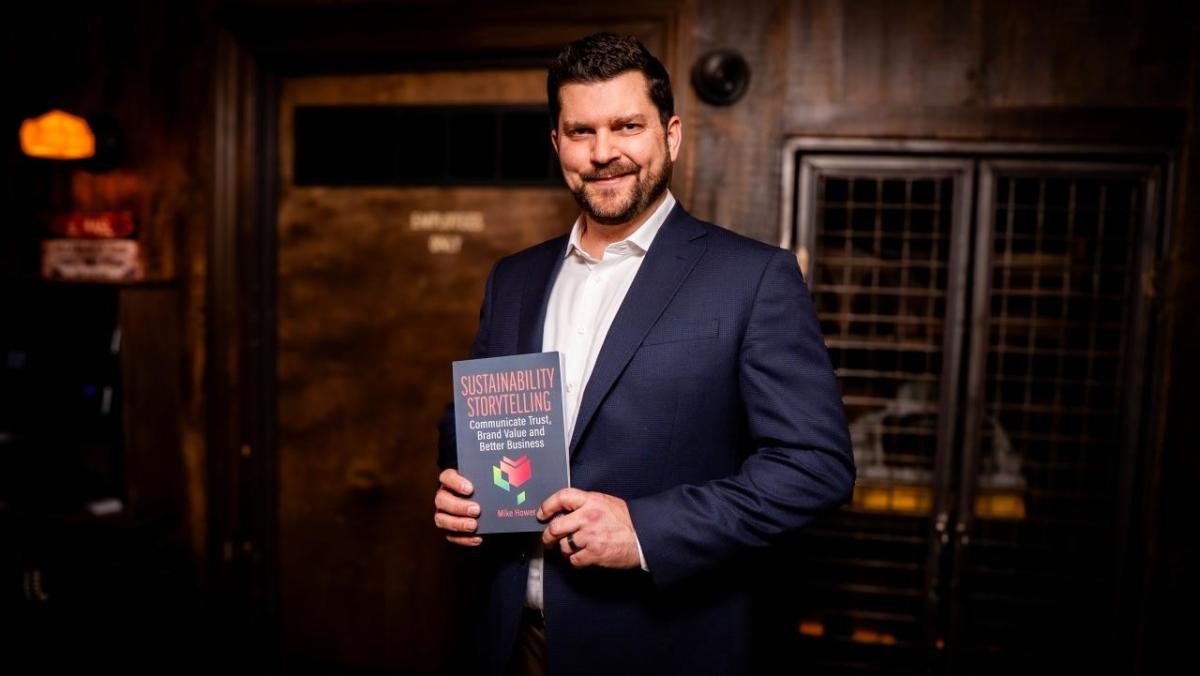 Mike Hower holding his new book