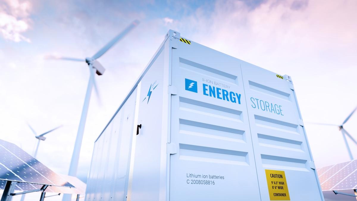 Energy storage container with windmills and solar panels in background