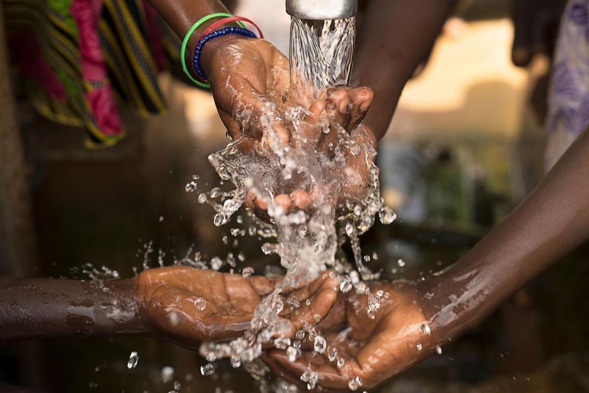Stream of water pouring into children’s hands in southern Burkina Faso.