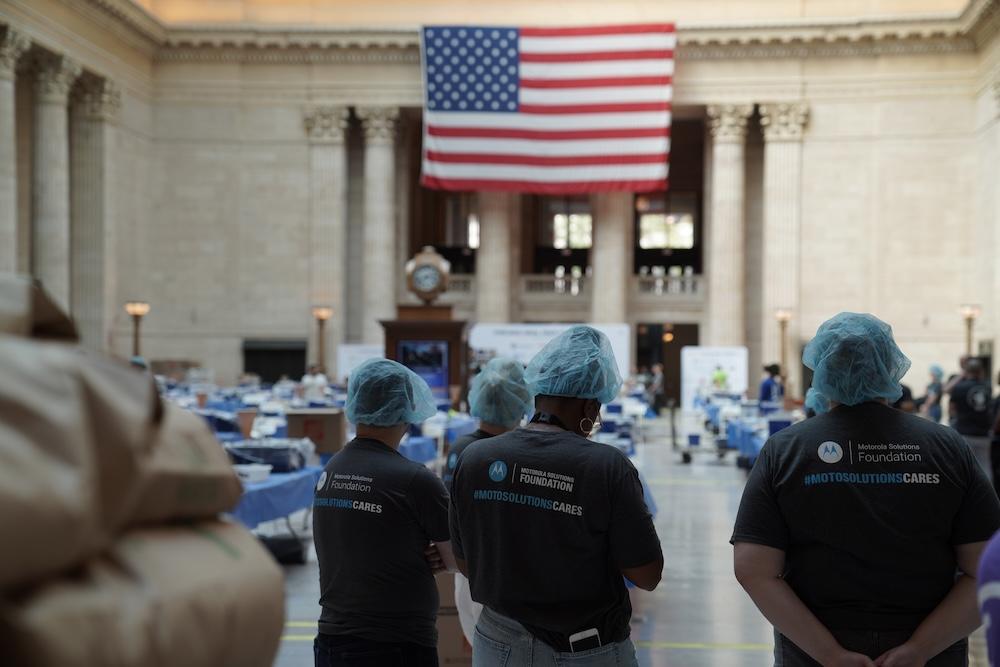 Volunteers standing by flag