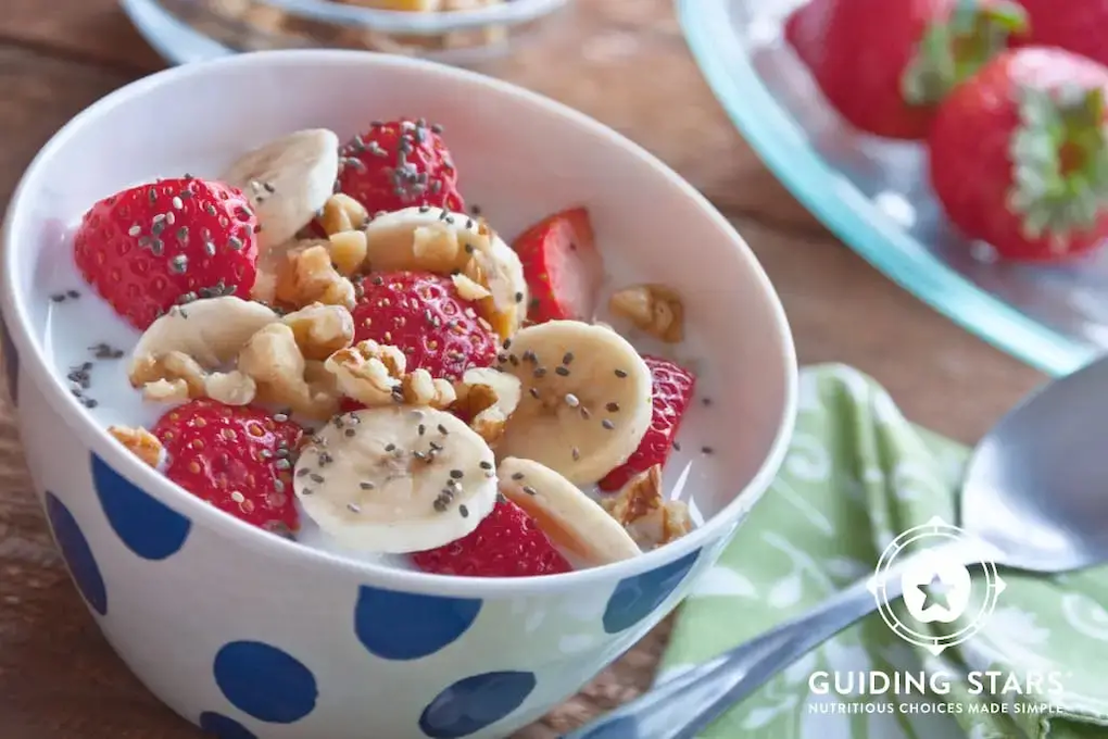 A healthy breakfast shown with oats, strawberries and bananas.