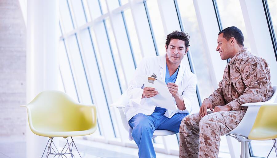 Doctor speaking with patient in military uniform