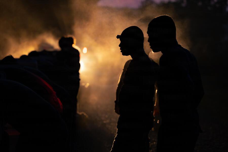 group of people standing in the dark with one light