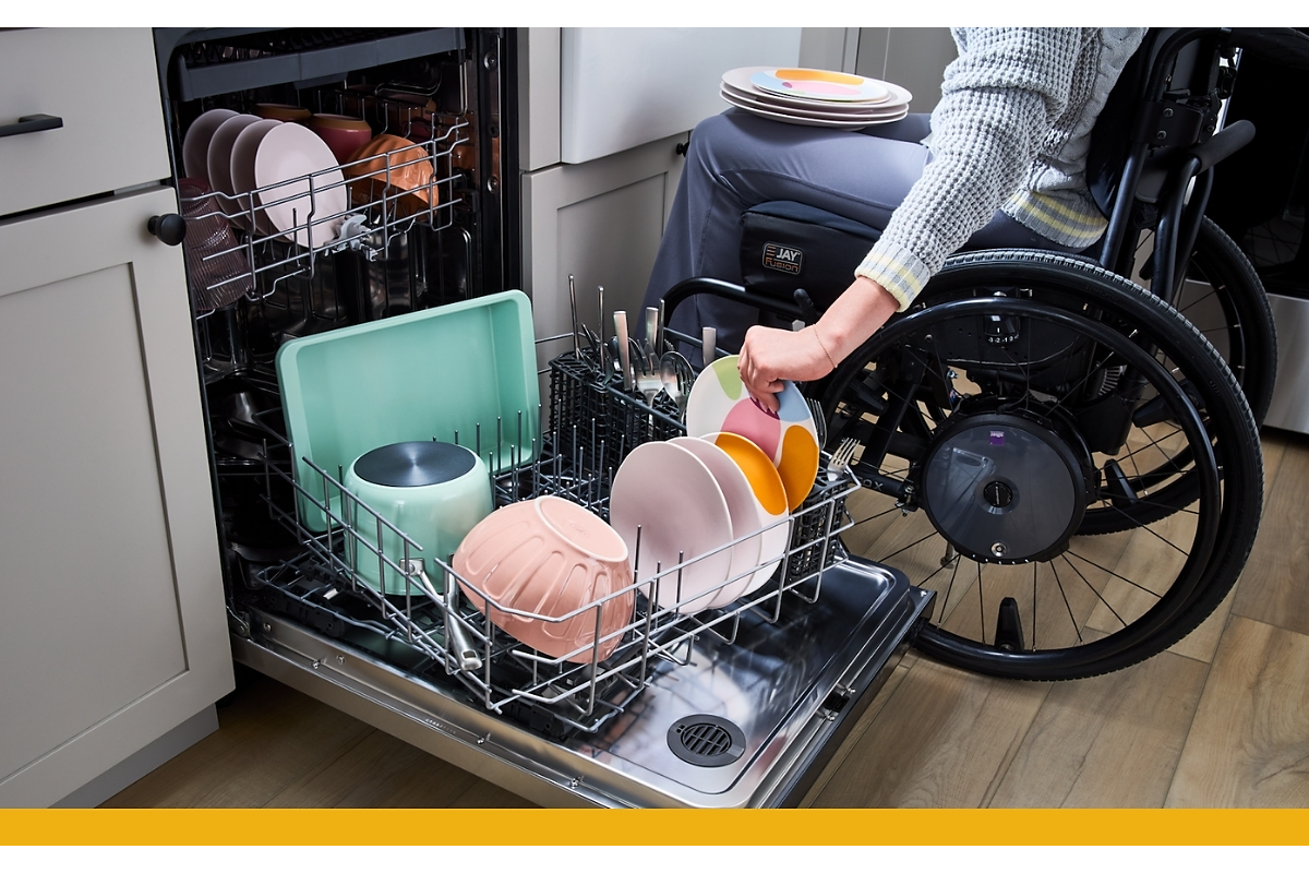 person in a wheelchair loading a diswasher