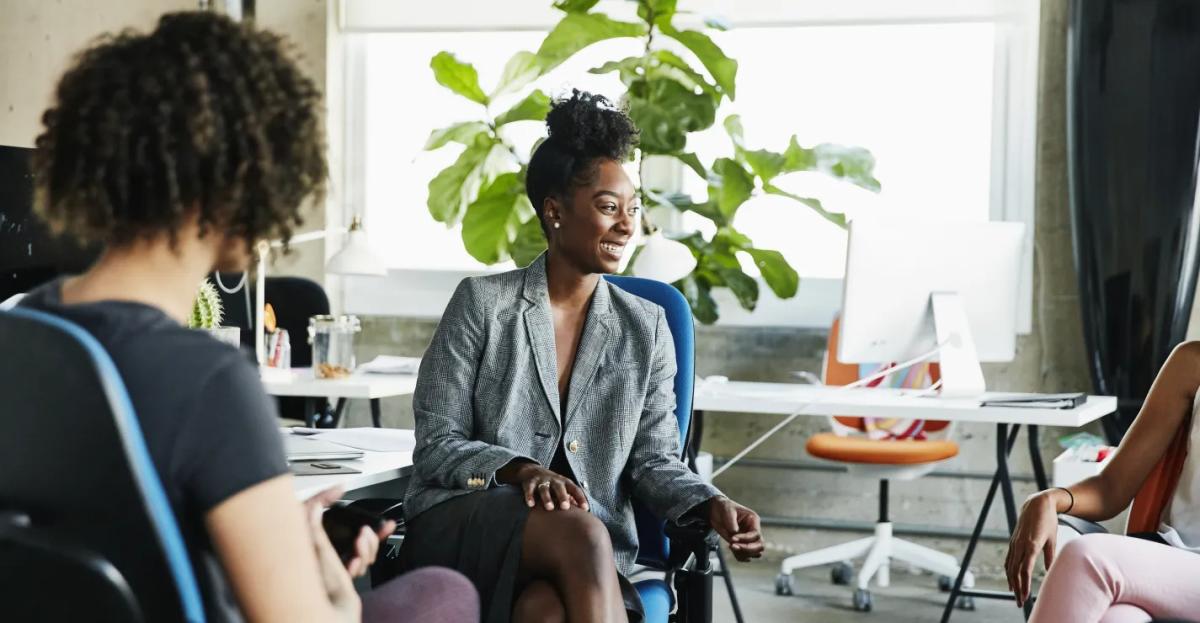 Office meeting with three women seated in an open environment
