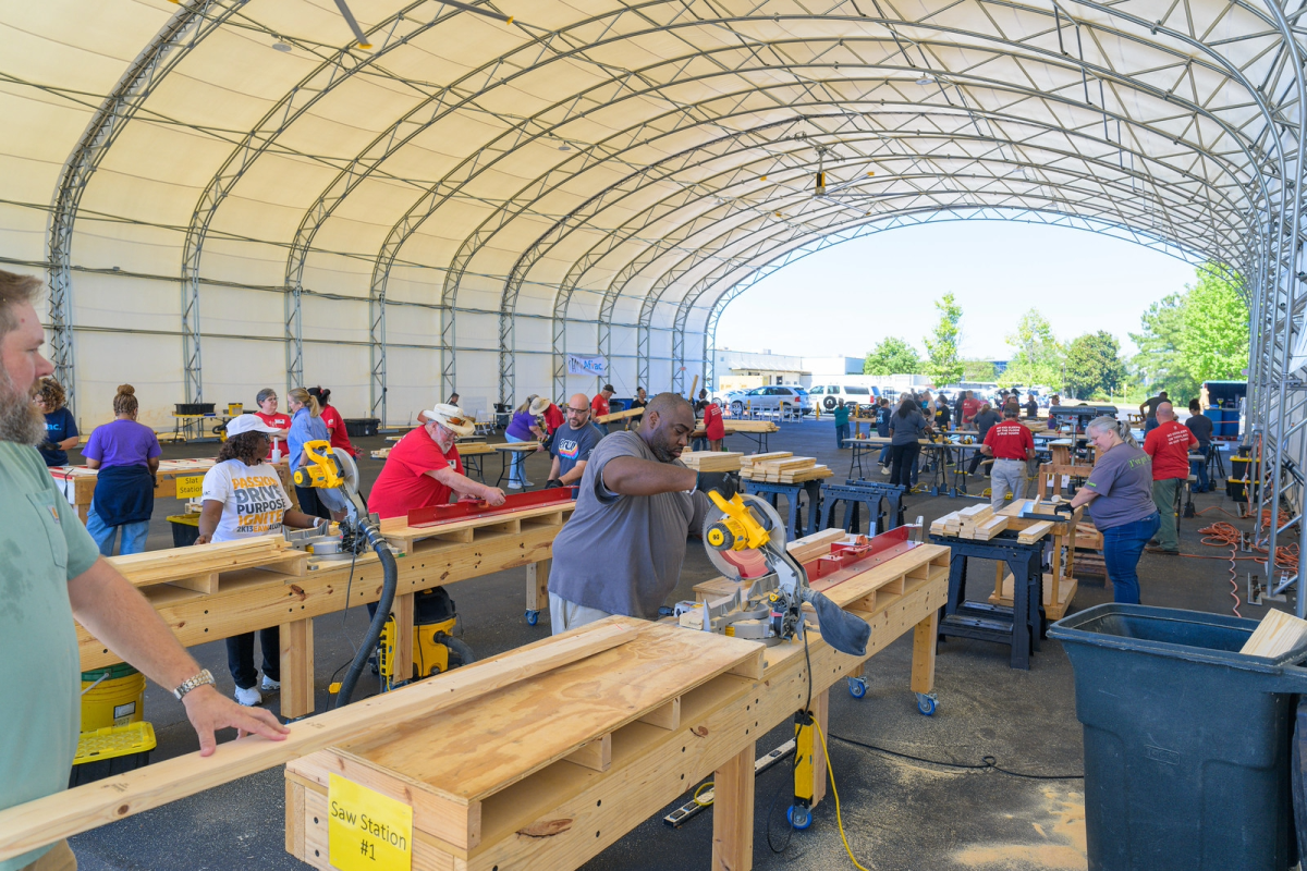Aflac volunteers building beds in a hanger.