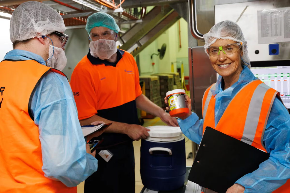 three people working in an industrial facility