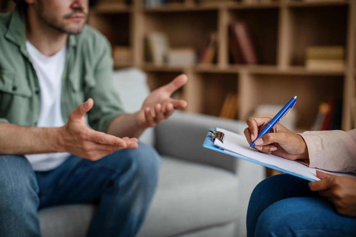 Two people conversing, one is writing on a clipboard