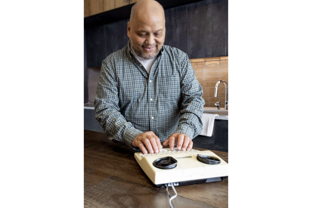 man typing on an assistive device 