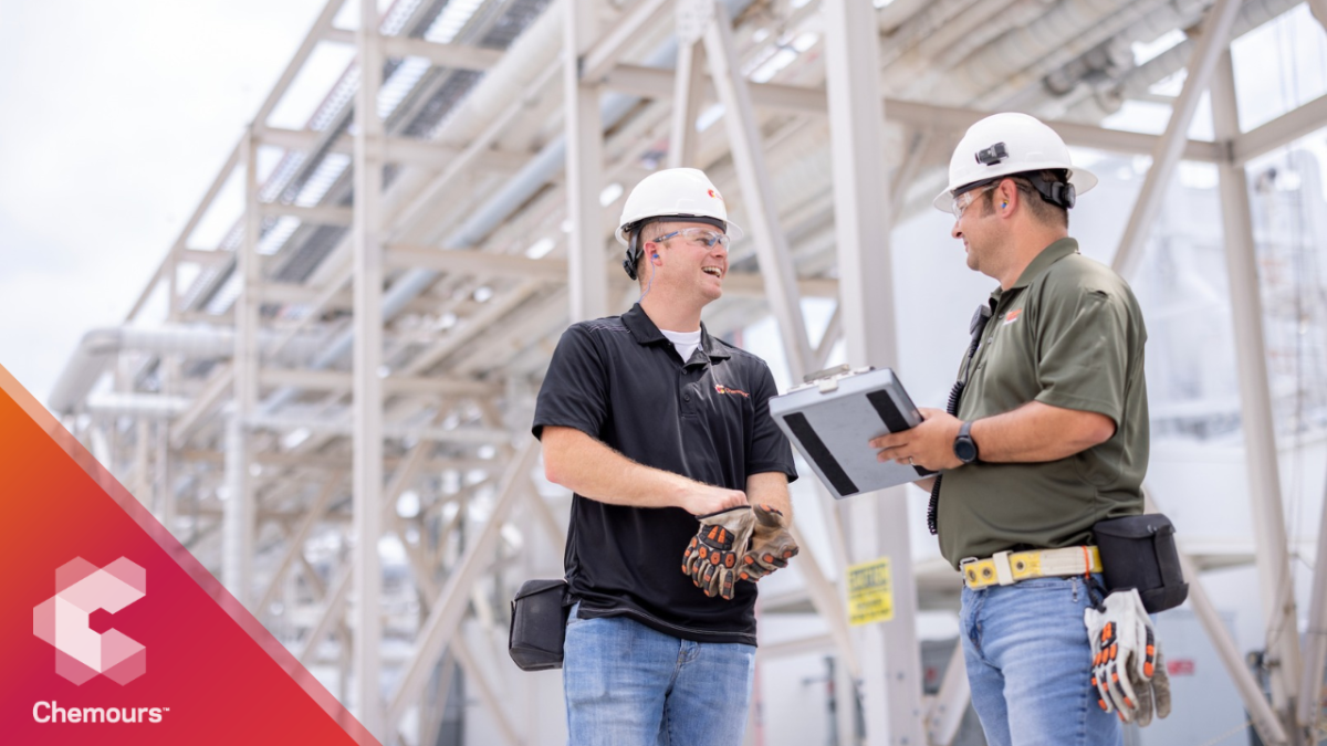 two workers in hard hats talking