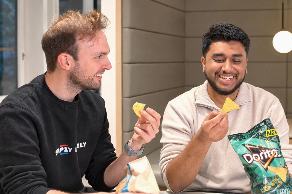 two smiling people eating Doritos