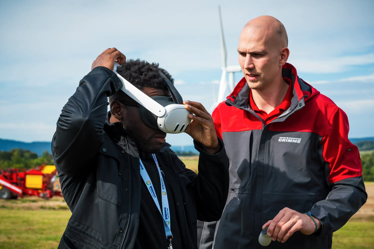 someone putting on a virtual headset while another looks on