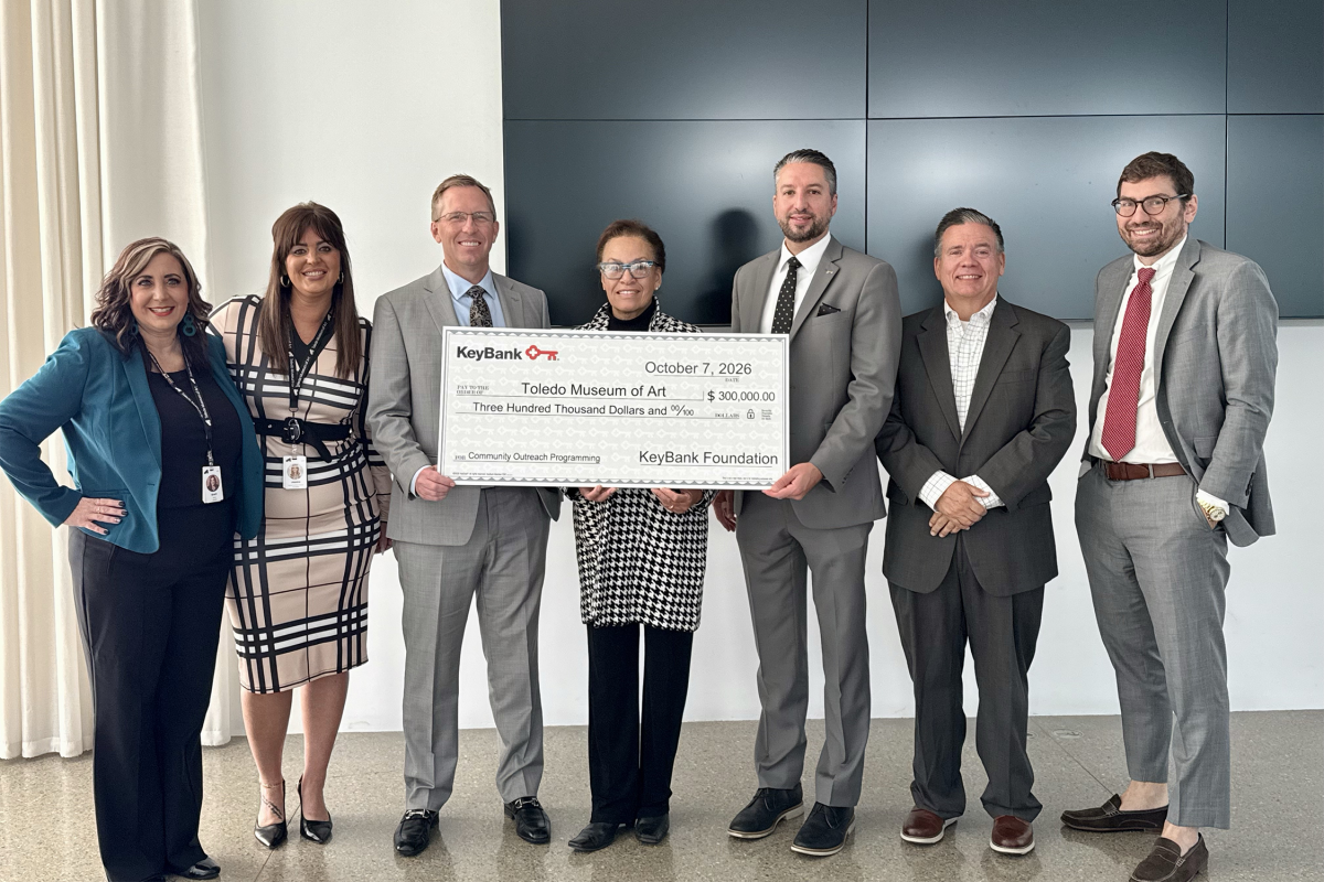 a small group posing with an oversized check