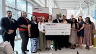 people holding up decorative check at event