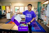 A child opening a purple box with supplies in it