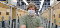 Photo of man in green t-shirt with a mask covering his nose and mouth